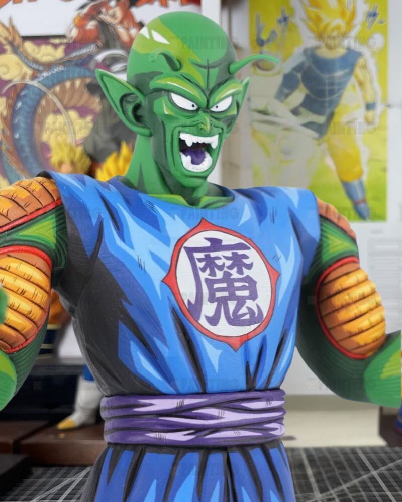 A detailed collectible statue of the Dragon Ball Z character Piccolo Sempai, featuring his green skin, blue gi, and orange arm bands, set against a background of Dragon Ball posters.
