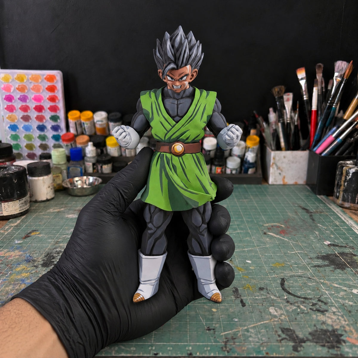 Dragon Ball Z Clearise Gohan Great Saiyaman Figure Repaint — held securely in one gloved hand in the workshop