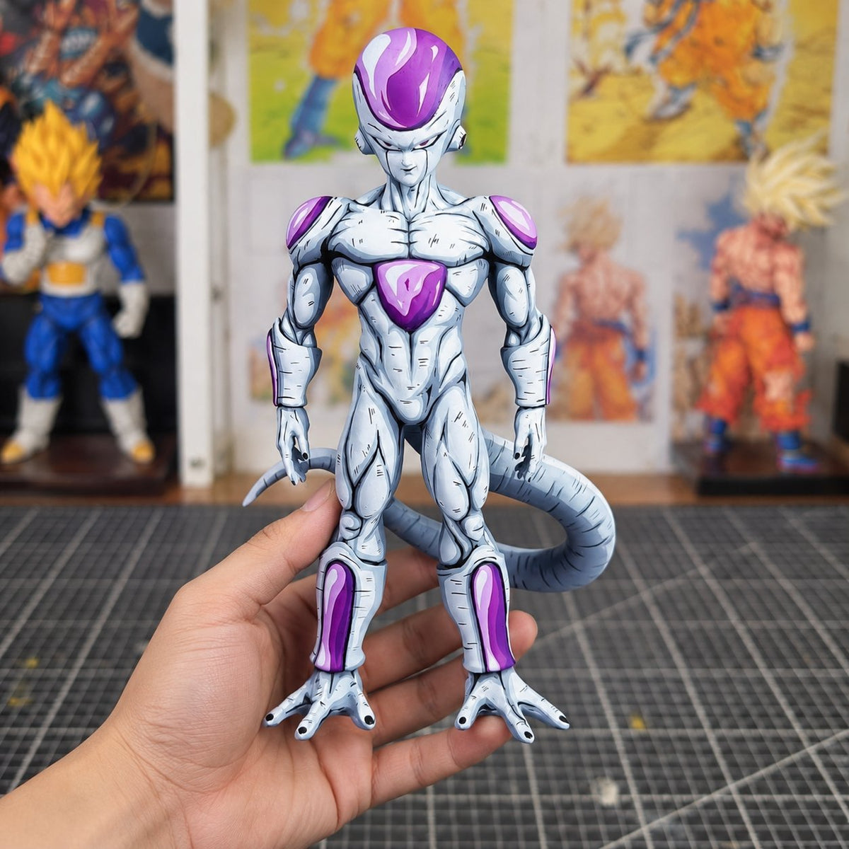 Frieza Final Form 2D Painted Figure — figure held in hand in a painting workshop
