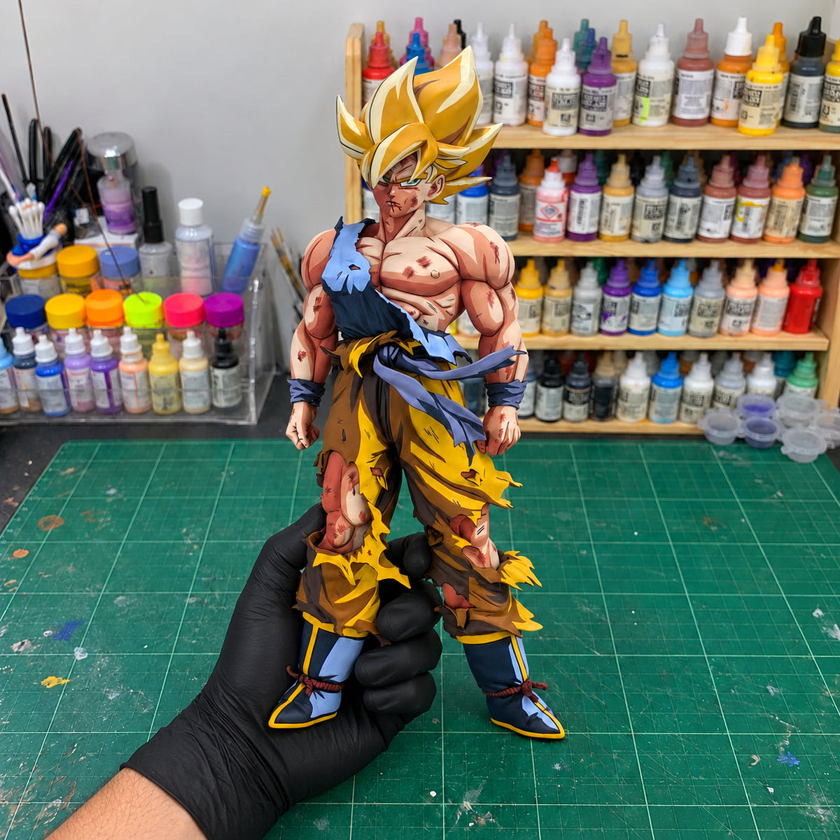 Dragon Ball Goku Namek Manga Colour Figure Repaint — held securely in one gloved hand in the workshop
