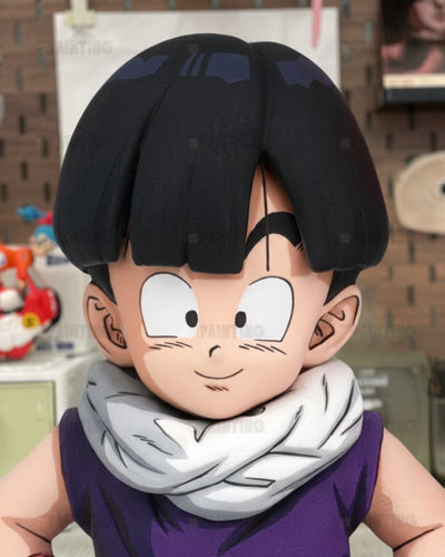 A close-up of an anime-style collectible figure or bust of a character with black hair, large white eyes, a white scarf, and a purple sleeveless top, shown against an indoor blurred background.