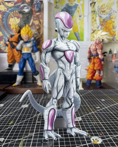 A detailed collectible figure of Fierce White from Dragon Ball Z standing on a black gridded cutting mat, with blurred Dragon Ball character figures in the background.