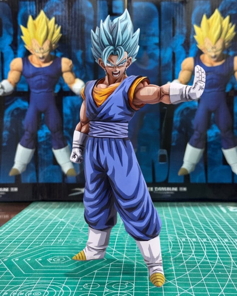 A Super Saiyan Blue action figure posed in a fighting stance on a green cutting mat, with the original packaging box blurred in the background.