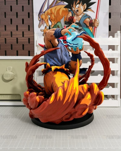 Dragon Ball Z Super Saiyan Gohan vs. Goku Z-Focus Statue, featuring Goku in a blue gi surrounded by orange and yellow energy effects on a black base, set against a white slatted backdrop with a Dragon Ball Z poster.