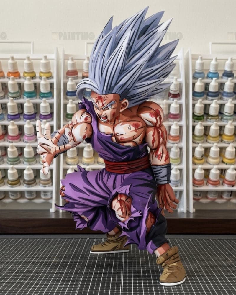 A highly detailed collectible action figure of Goku in a Super Saiyan form, posed dynamically in a crouching stance. The figure features spiky silver hair, a purple gi, and a muscular, battle-scarred skin with red markings.