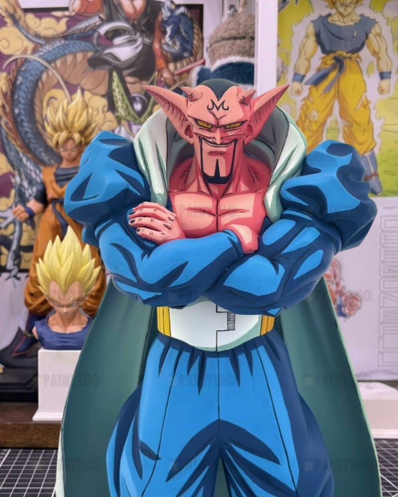 A detailed collectible statue of the anime character Cell from Dragon Ball Z, standing with arms crossed. The statue is set against a background of other Dragon Ball Z busts and posters.