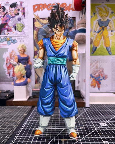 A detailed anime figurine of Gohan from Dragon Ball Z, standing on a black gridded cutting mat with Dragon Ball posters in the background.