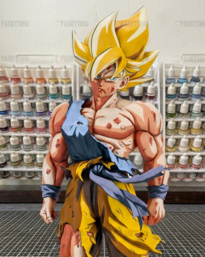 A large anime collectible figure of Goku in a Super Saiyan form, standing in front of shelves filled with paint bottles.