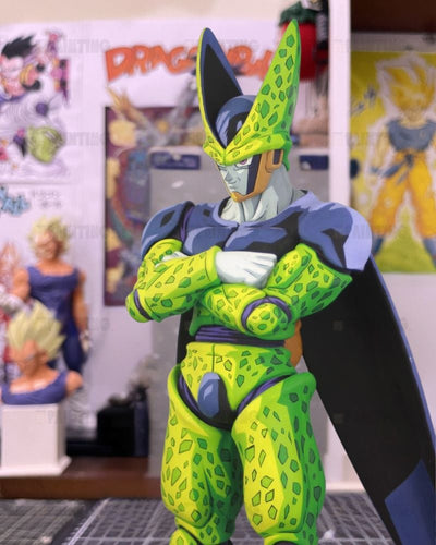 A Dragon Ball figure of Cell with arms crossed, standing in a collector's room with Dragon Ball posters in the background.