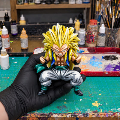 Blood Saiyans Special Gotenks Super Saiyan 3 Figure Repaint — held securely in one gloved hand in the workshop