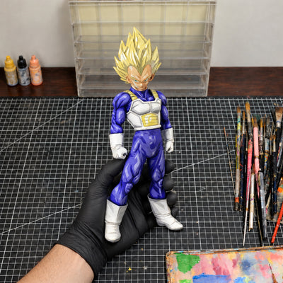Anime Style Dragon Ball Z SSJ2 Vegeta Figure Repaint — held securely in one gloved hand in the workshop